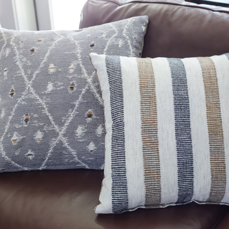 two simple decorative pillows on a leather couch