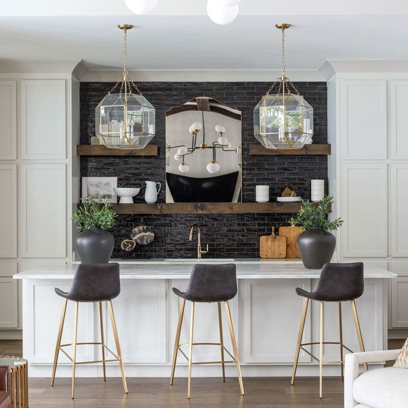 indoor bar with dark grey and gold bar stools and pendant lights